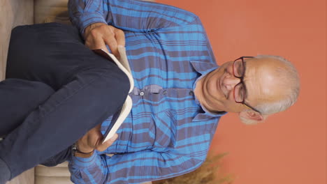Vertical-video-of-The-old-man-reading-the-book.